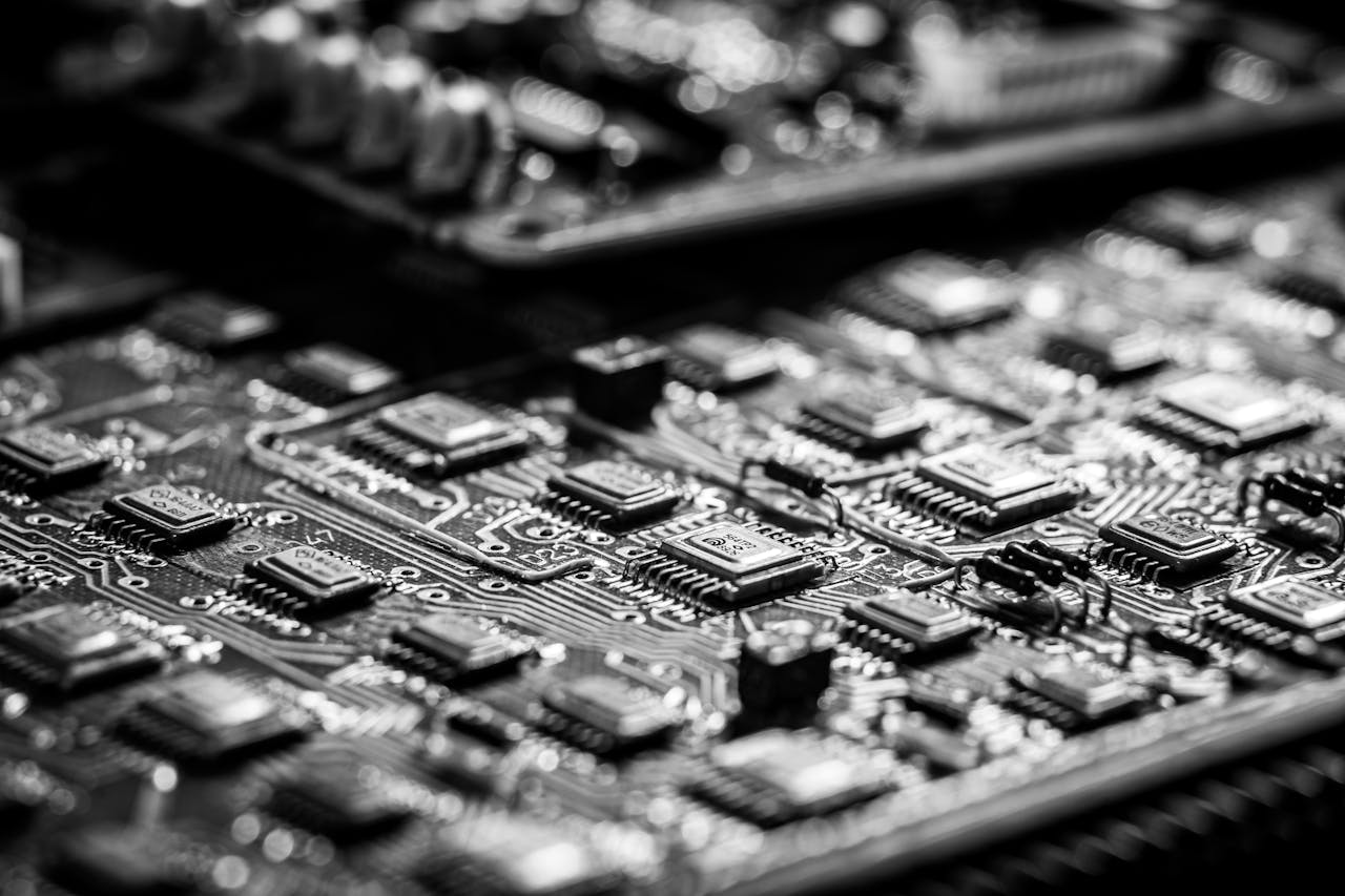 Detailed black and white close-up of a circuit board with microchips highlighting electronic components.